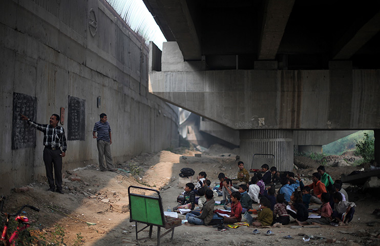 24 hours in pictures:  a free school run under a metro bridge in New Delhi, India