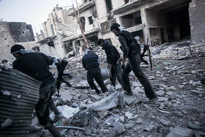 From The Agencies: Rebel fighters carry a bomb through the streets