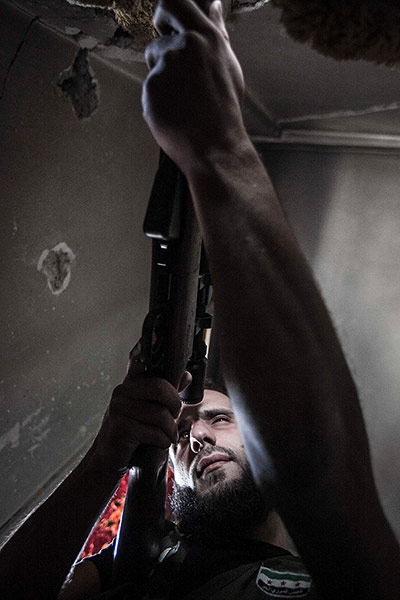 From The Agencies: A rebel sniper keeps an eye on his enemy's position