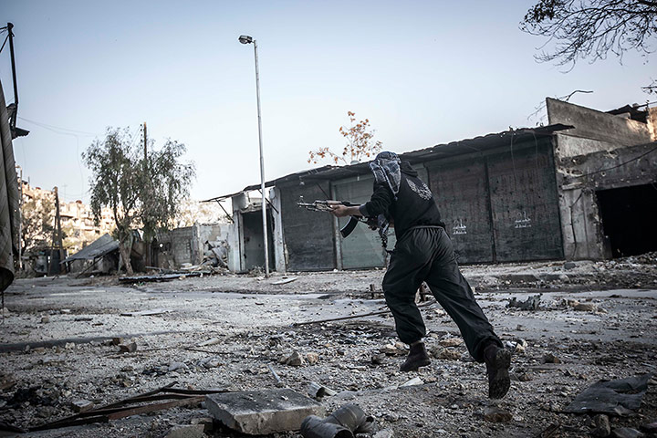 From The Agencies: A rebel fighter runs for cover through a sniper line-of-fire