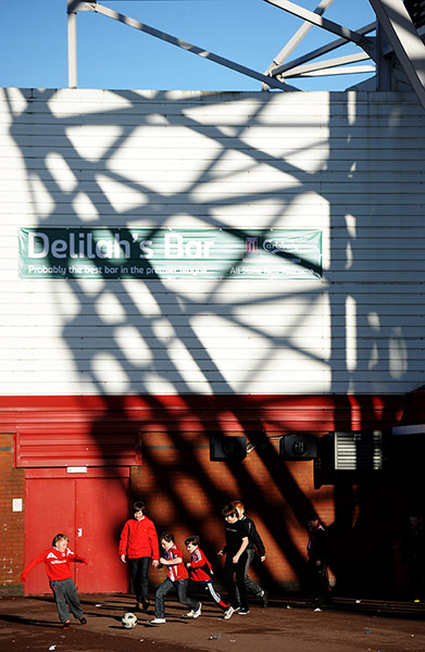 Joy of six stadiums: Children play football outside the ground 