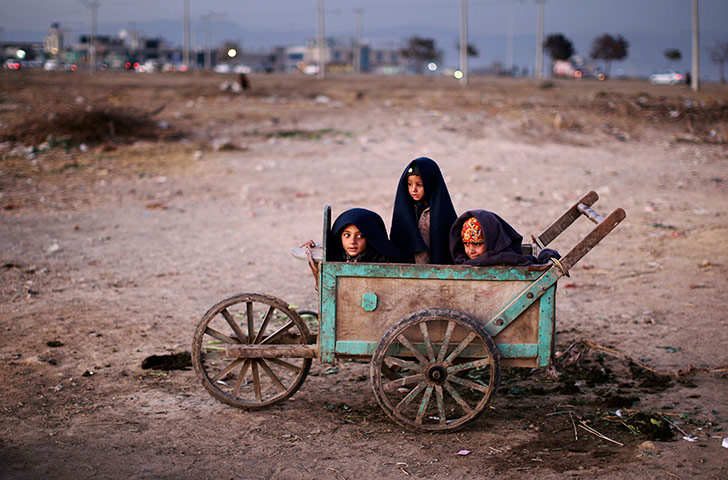 20 Photos: Afghan refugee boys wrap themselves with blankets to avoid the evening cold