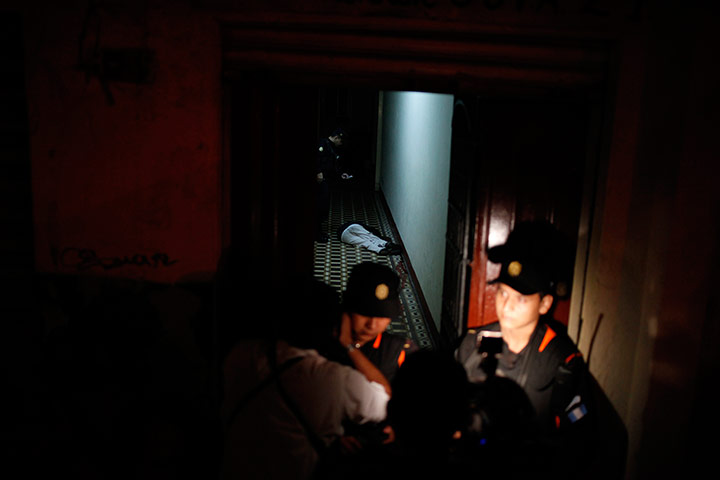 24 Hours: A police officer takes a picture next to a body in Guatemala City