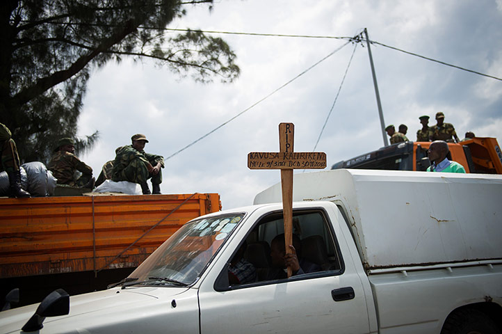 Goma: A funeral cortege drives past trucks of Congolese M23 rebels