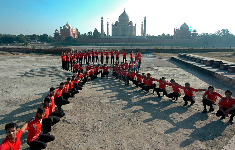 World Aids Day: Agra, India: Students form the shape of an Aids ribbon near the Taj Mahal
