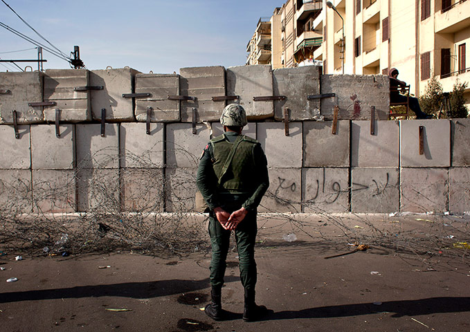 Egypt protests: A soldier stands guard in front of the presidential palace