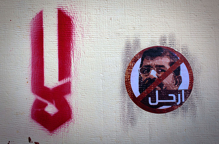 Egypt protests: A sticker depicting president Morsi, with Arabic that reads 'leave'