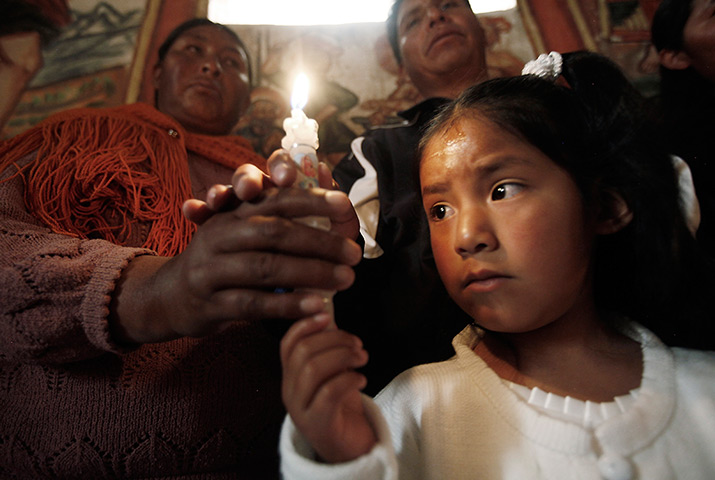 24 hours: Curahuara de Carangas, Bolivia: A girl holds a candle at her baptism