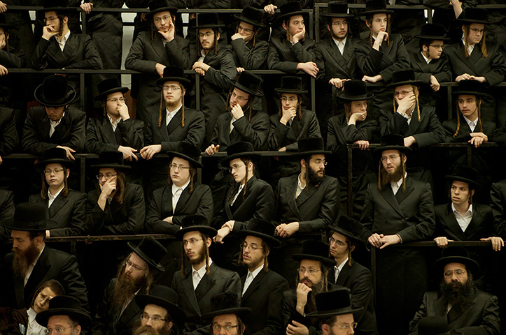 24 hours in pictures: Ultra Orthodox Jewish men sit during a celebration Hanukkah 