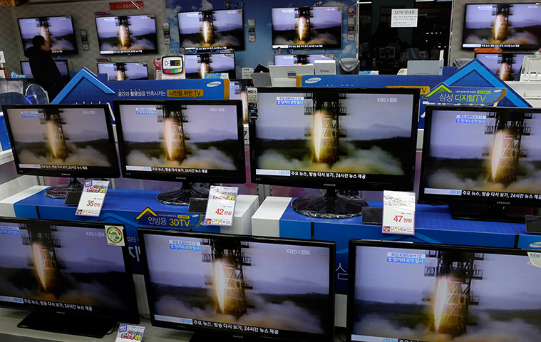 North Korea missile: A clerk watches TV screens, airing file footage