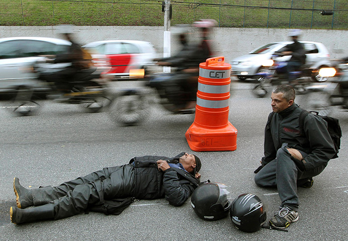 24 hours: Sao Paulo, Brazil: Motorcycle couriers wait for an ambulance