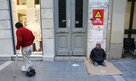 Two beggars wait on a sidewalk in Thessaloniki on December 13, 2012. 