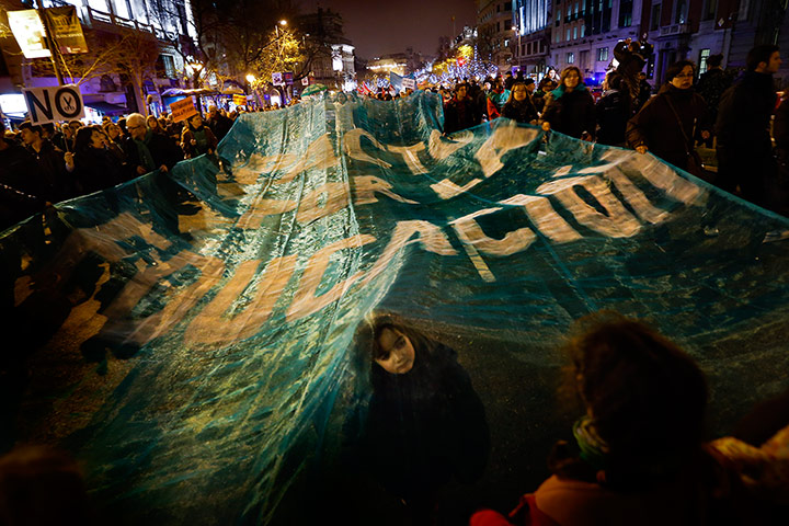 24 hours: Madrid, Spain: A girl looks out from under a banner during a protest