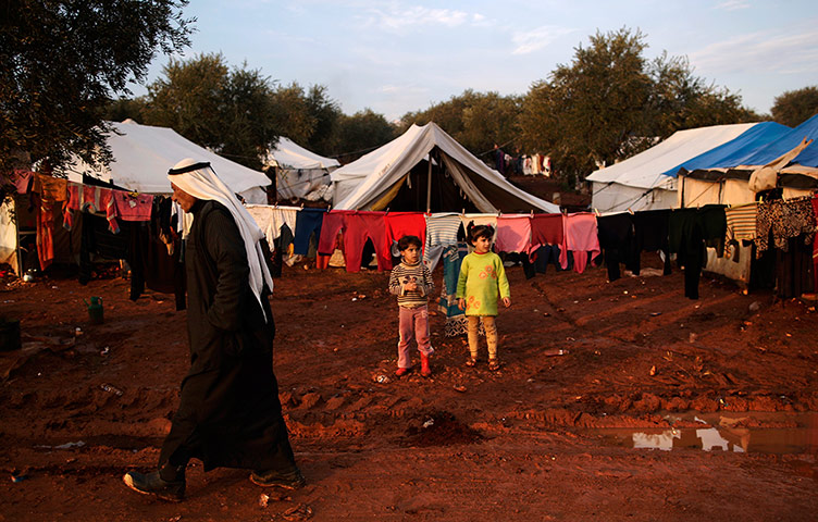 24 hours: Atmeh, Syria: Children stand next to tents