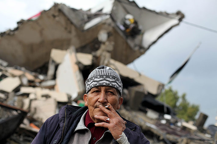24 hours: Gaza: A Palestinian man stands in front of rubble in an area hit by Israeli air strikes in the recent conflict 