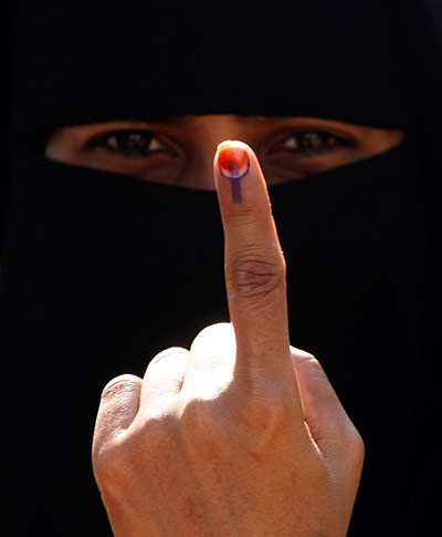 24 hours: Surat, India: A woman displays her finger after casting her vote