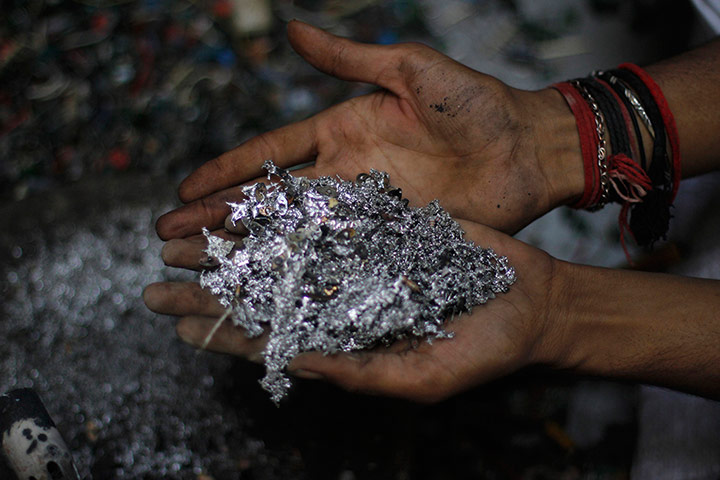 24 hours: Karachi, Pakistan: A boy holds metal from computer circuit boards
