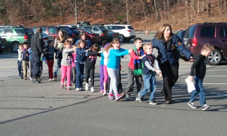In this photo provided by the Newtown Bee, Connecticut state police lead children from the Sandy Hook elementary school.