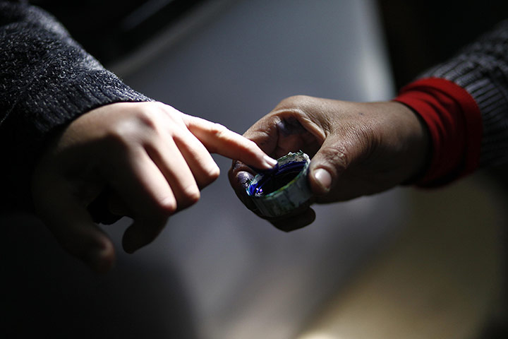 Egypt Referendum: An Egyptian man dips his finger in ink after casting his vote