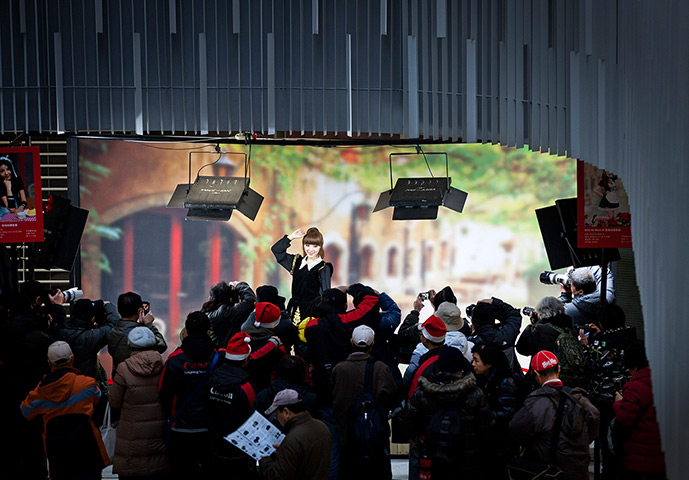 24 hours in pictures: A model poses for Chinese amateur photographers during a workshop