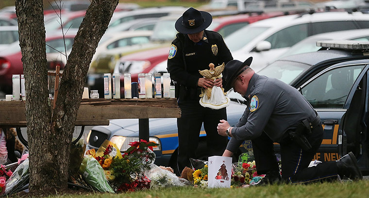 Sandy Hook: Newtown Police officers leave mementos at a makeshift memorial