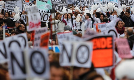 Protesters march with banners reading 'No financial cuts' during a demonstration against regional government-imposed austerity plans to restructure and part-privatise health care sector in Madrid, Spain, Sunday, 16 December 2012.