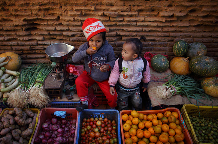 24 hours: Bhaktapur, Nepal: A girl eats oranges
