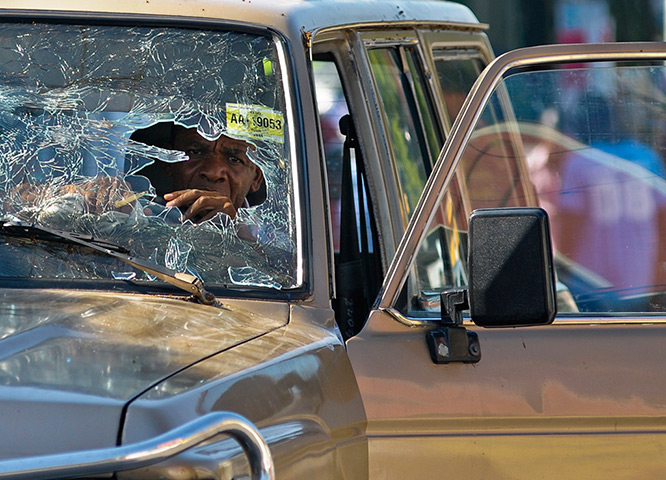 24 hours: Port-au-Prince, Haiti: A man sits in his car witha shattered windscreen