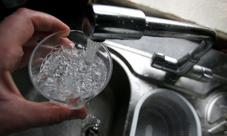 Glass of water being poured from tap