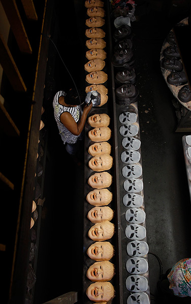 24 hours in pictures: A worker puts finishing touches on masks at a factory