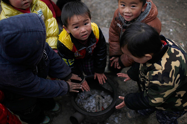 FTA: Aly Song: Children warm their hands over a fire