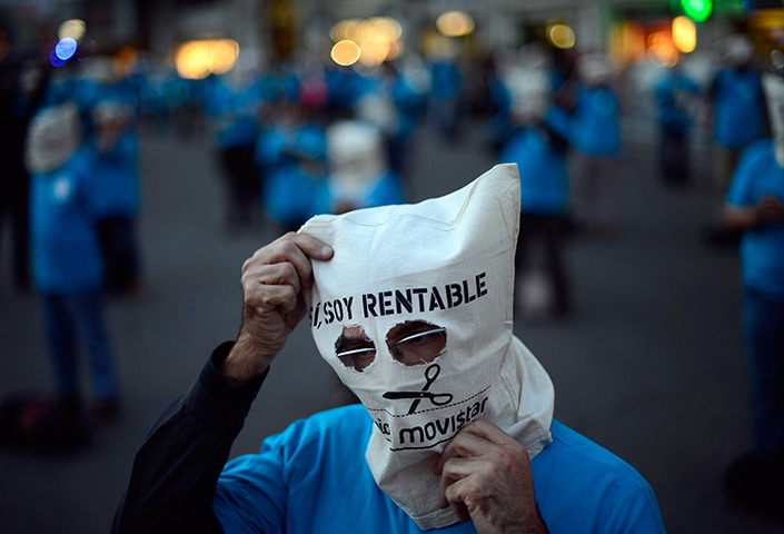 24 hours in pictures: Masked demonstrators protest on a street in Barcelona, Spain