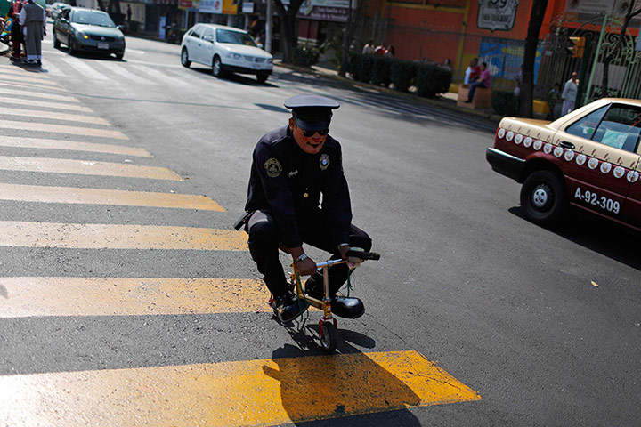 Lighter Look: A clown dressed as policeman rides his mini bicycle