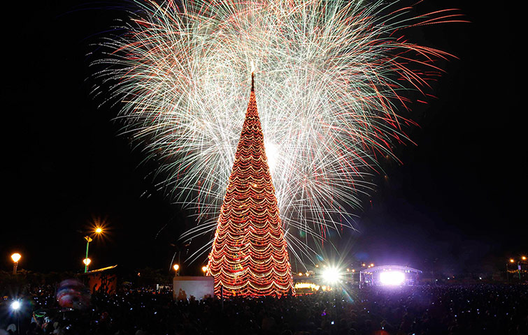 24 Hours: Palawan, Philippines: Fireworks light the sky near a giant Christmas tree