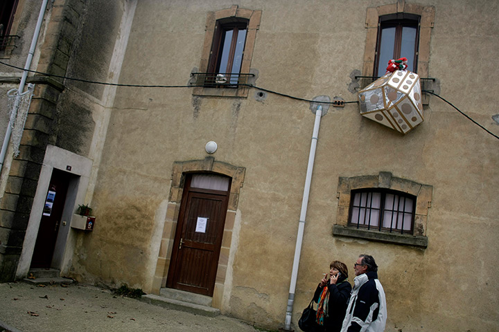 Bugarach prophecy: People walk past a model meant to represent a UFO 