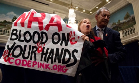 A protestor is removed by a security guard during a speech by Wayne LaPierre, the executive vice president of the National Rifle Association during a news conference in Washington.