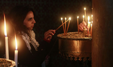 Mujer luces de una vela en la iglesia