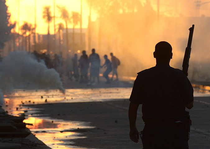24 hours: A policeman disperses looters after an a looting