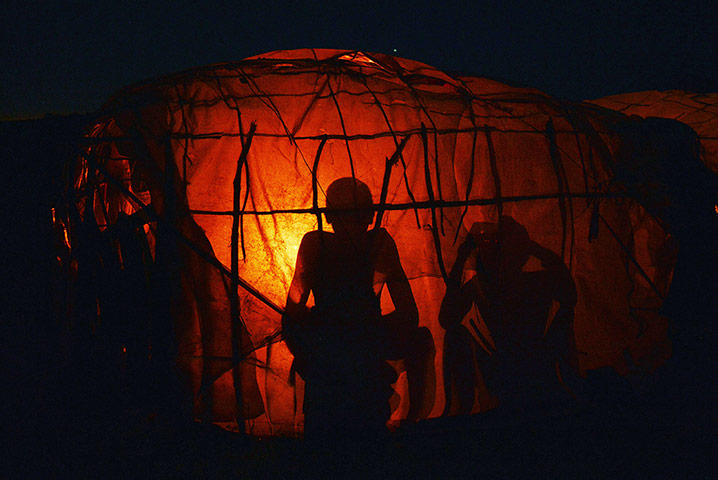 24 hours: Maasai children sit near a fire inside a hut