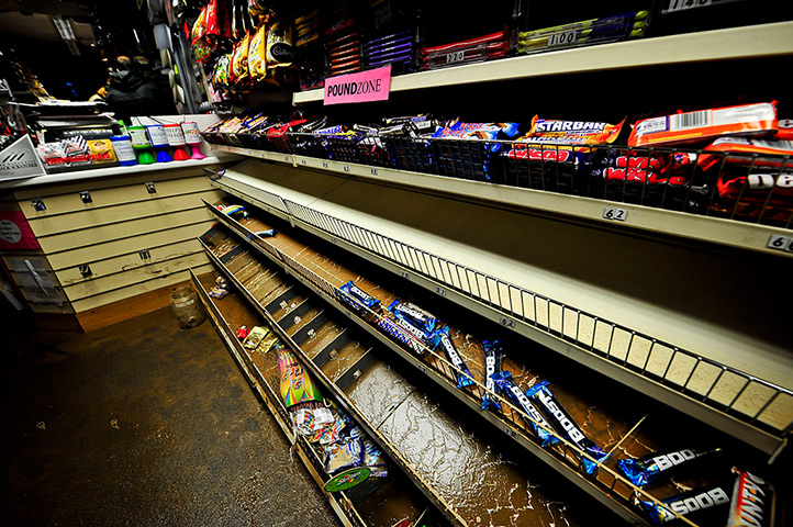 Wet weather: Sweets on water-damaged racks covered in silt in a shop 