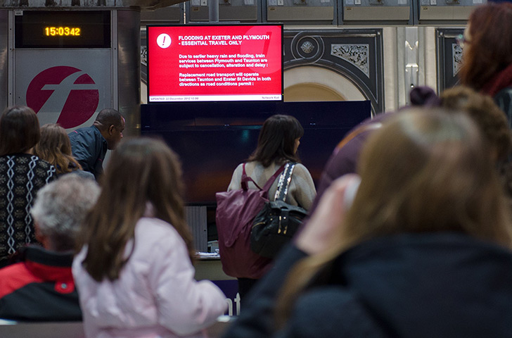 Wet weather: Travellers look at a sign in Paddington station