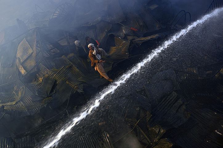 24 hours: Kabul, Afghanistan: Afghan men guide firefighters after a huge fire