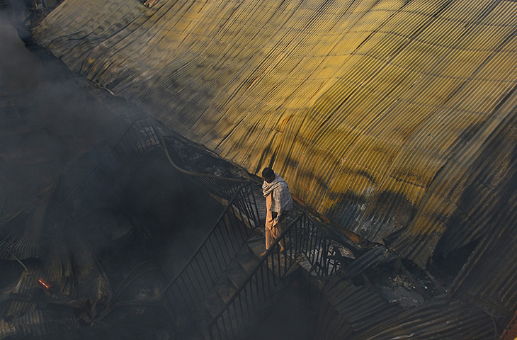 Kabul fire: A man walks through the fire-destroyed market 