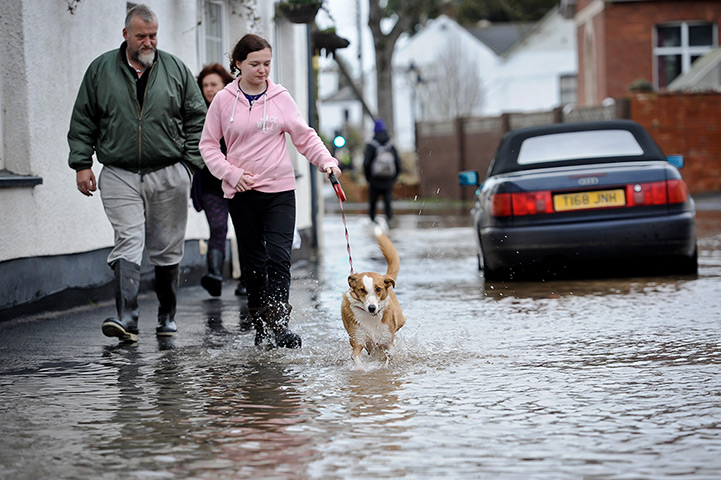 Uk flooding continues: Villagers walk through flood water in the high street in Stoke Canon, Devon