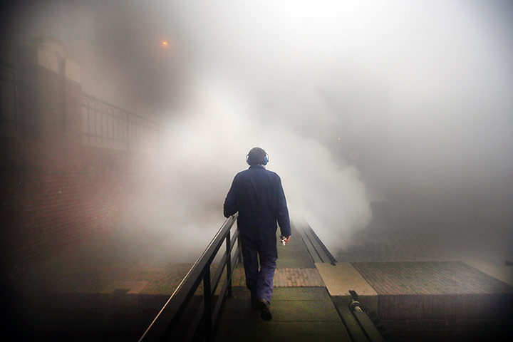 24 hours in pictures: A man walks on a platform as steam rises