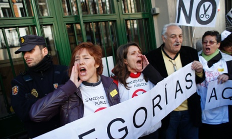 Demonstrators shout slogans during a protest against the local government's plans to cut spending on public health care, outside Madrid's health regional office in Madrid December 27, 2012. 