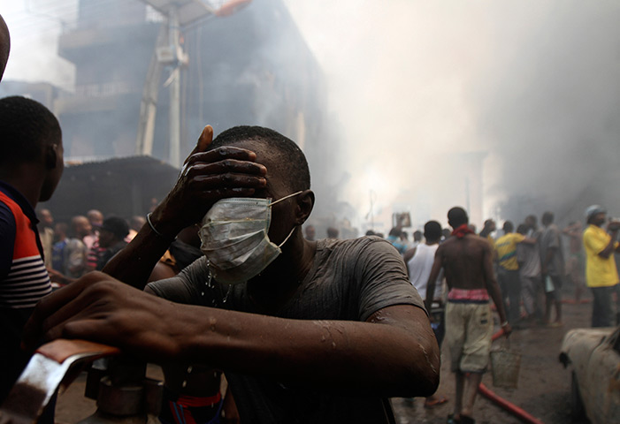 24 hours in pictures: A volunteer cleans his face near the site of a fire, Nigeria