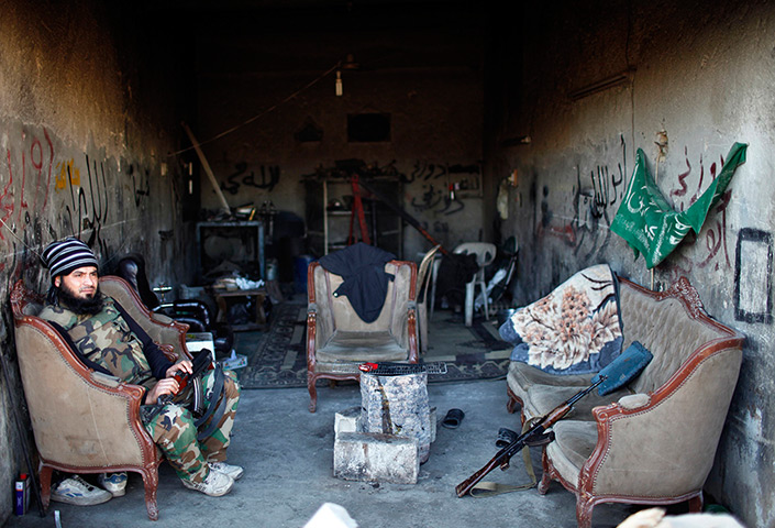 24 hours in pictures: A Free Syrian Army fighter sits in a garage 
