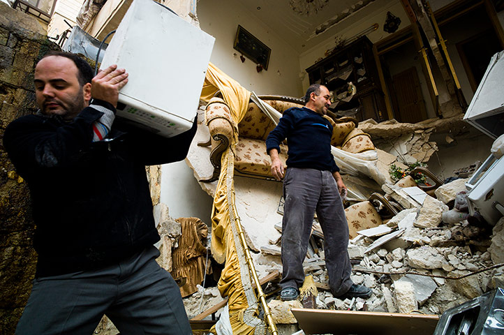Residents in the Saif al-Dawla area of Aleppo try to salvage belongings from their houses