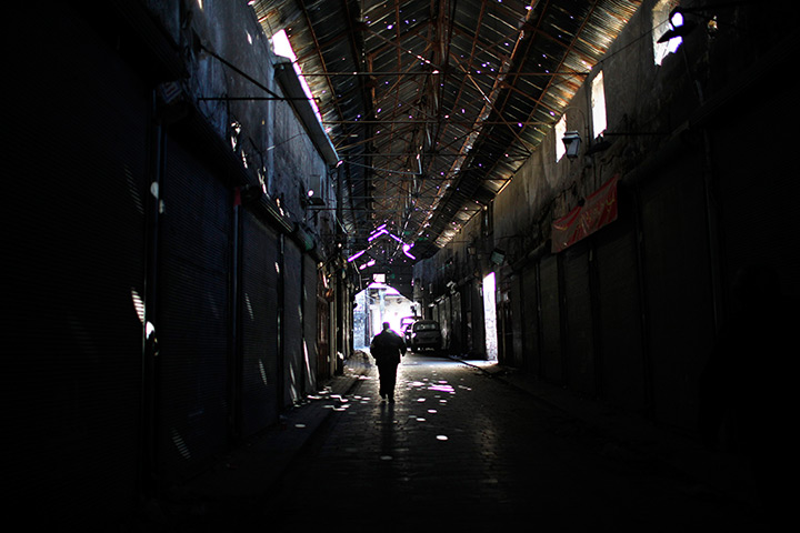 24 hours in pictures: A Free Syrian Army fighter walks in the market of Aleppo